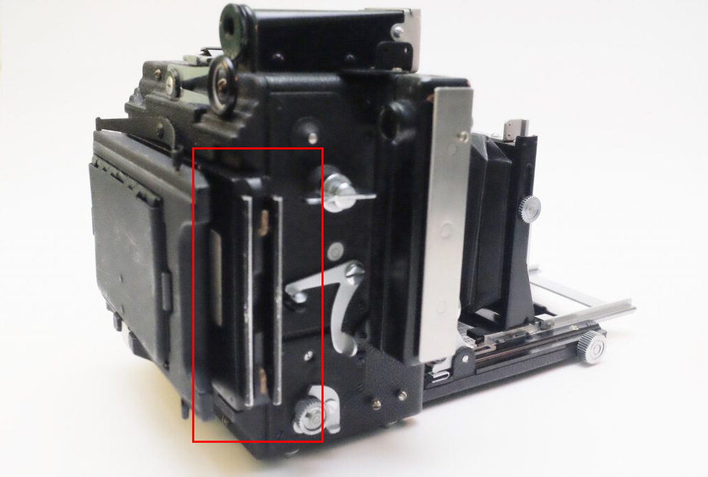 Film holder sandwiched between the ground glass viewer and the camera body